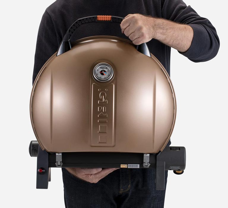 A person is holding O-Grill 900MT Portable Gas Grill